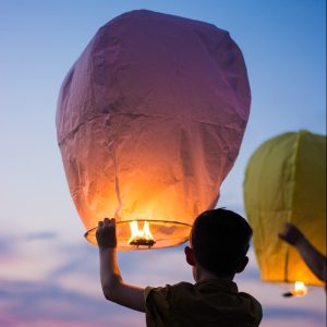 person holding yellow flammable balloon